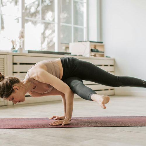 Woman in a challenging yoga pose, demonstrating flexibility.